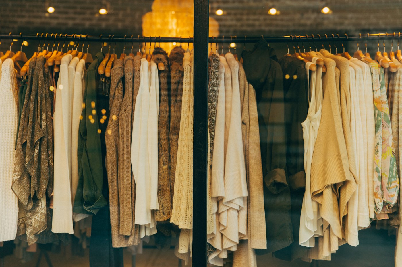 Perchas de una tienda de moda en tonos cálidos